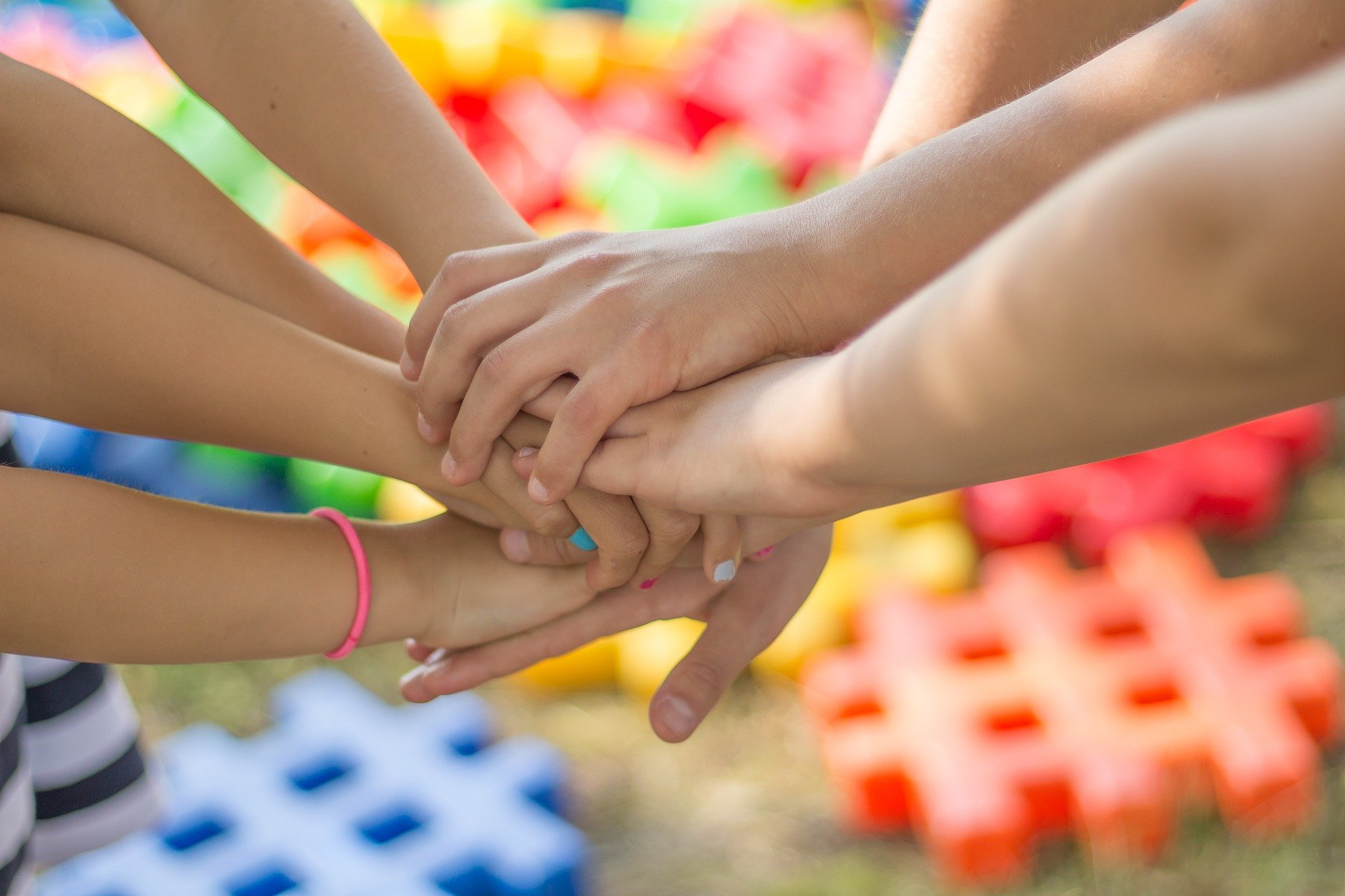 The image shows several hands stacked on each other.